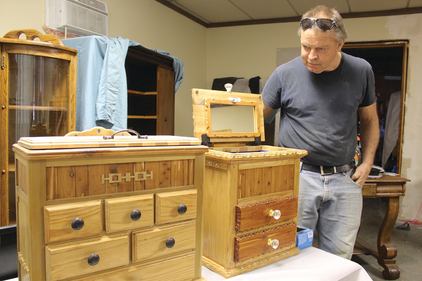 Craftsman Jeff Osborn displays some of his recent woodworking projects Monday inside an old business he purchased on East Main Street. Osborn looks to open a business in the dilapidated building this fall following extensive renovation efforts.